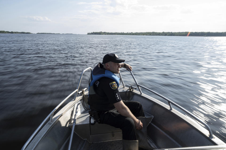A police officer patrols area of Kakhovka reservoir on Dnipro river near Lysohirka, Ukraine, Thursday, May 18, 2023. Damage that has gone unrepaired for months at a Russian-occupied dam is causing dangerously high water levels along a reservoir in southern Ukraine. (AP Photo/Evgeniy Maloletka)