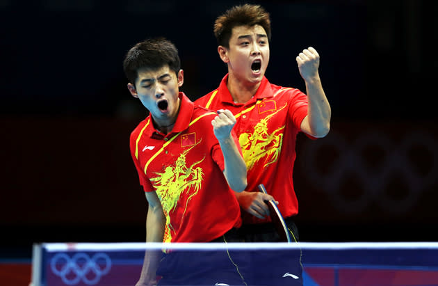 LONDON, ENGLAND - AUGUST 06: Jike Zhang and Hao Wang of China celebrate victory against Timo Boll and Bastain Steger of Germany in the doubles match of the men's team competition during the 2012 London Olympics at the ExCeL North Arena on August 06, 2012 in London, England. (Photo by Ian MacNicol/Getty Images)