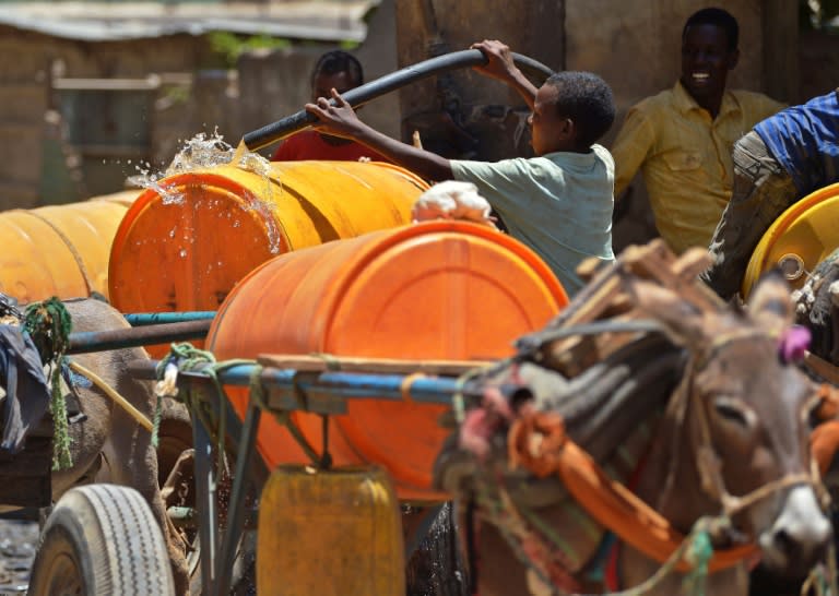 A boy fills a water drum on a donkey cart in Baidoa, in the southwestern Bay region of Somalia