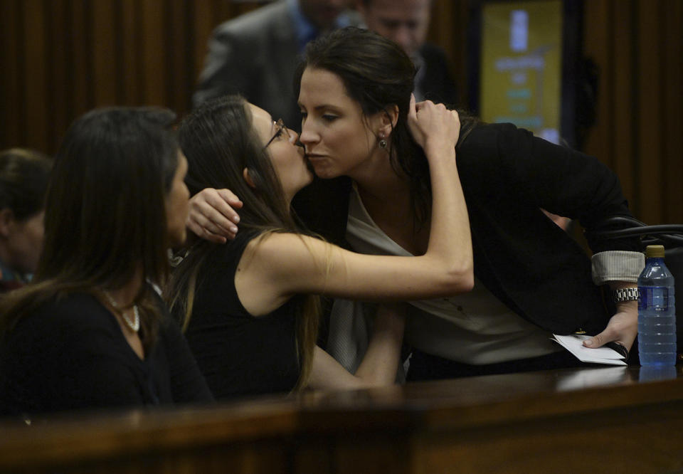 Aimee Pistorius, right, sister of Oscar Pistorius, is greeted by an unidentified relative as she arrives at a court for her brother's ongoing murder trial in Pretoria, South Africa, Friday, March 14, 2014. Pistorius is charged with the shooting death of his girlfriend Reeva Steenkamp, on Valentines Day in 2013. (AP Photo/Phill Magakoe, Pool)