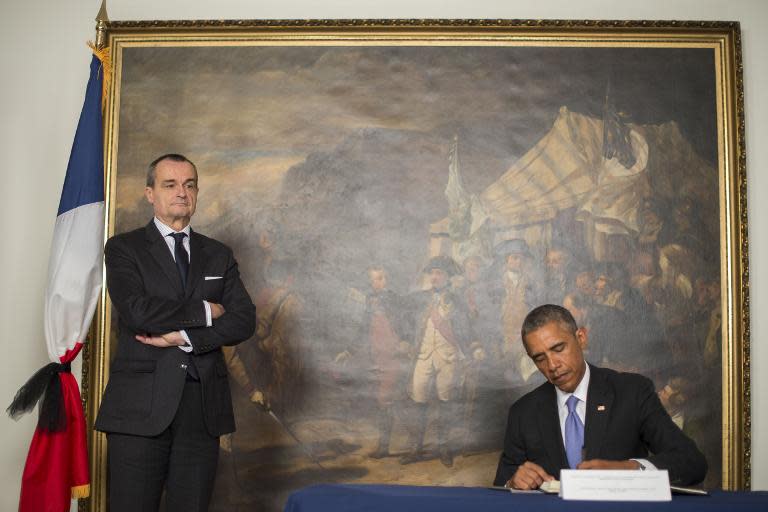 US President Barack Obama signs the condolence book beside French Ambassador to the United States Gérard Araud in Washington, DC, January 8, 2015, to honor the 12 victims of the Islamist attack on the satirical magazine Charlie Hebdo in Paris