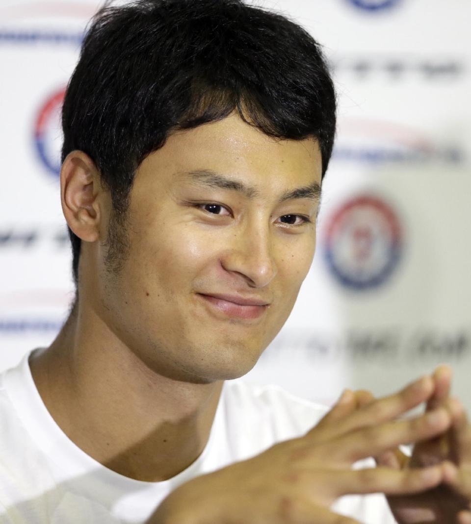 Texas Rangers' Yu Darvish of Japan smiles after responding to a question at a news conference during spring training baseball practice, Tuesday, Feb. 18, 2014, in Surprise, Ariz. (AP Photo/Tony Gutierrez)