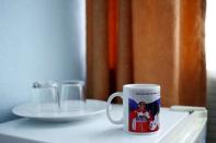 A mug decorated with pictures of Russian President Vladimir Putin, which reads "people should understand that a healthy way of life is a personal success of each and every of us", is seen in this photo illustration taken in a hotel room in Kazan, Russia, July 30, 2015. REUTERS/Stefan Wermuth