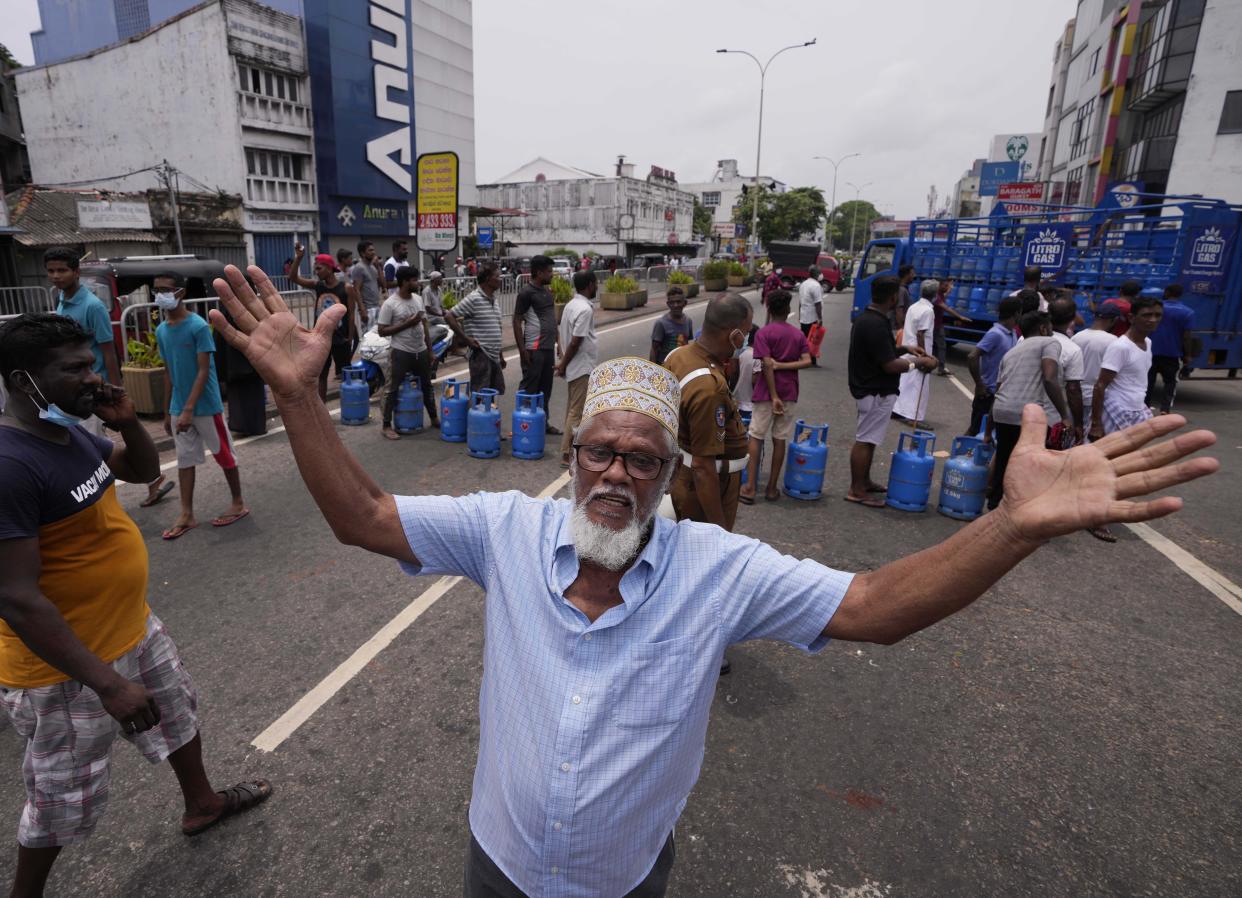 A Sri Lankan man shouts in jubilation after a truck carrying cooking gas arrived at a distribution center in Colombo, Sri Lanka, Sunday, May 8, 2022. Diplomats and rights groups expressed concern Saturday after Sri Lankan President Gotabaya Rajapaksa declared a state of emergency and police used force against peaceful protesters amid the country's worst economic crisis in recent memory.(AP Photo/Eranga Jayawardena)