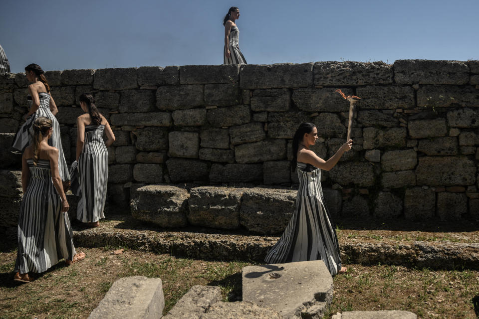 L’actrice grecque Mary Mina (R), tient la torche après l’avoir allumée lors de la répétition de la cérémonie d’allumage de la flamme des Jeux olympiques de Paris 2024.