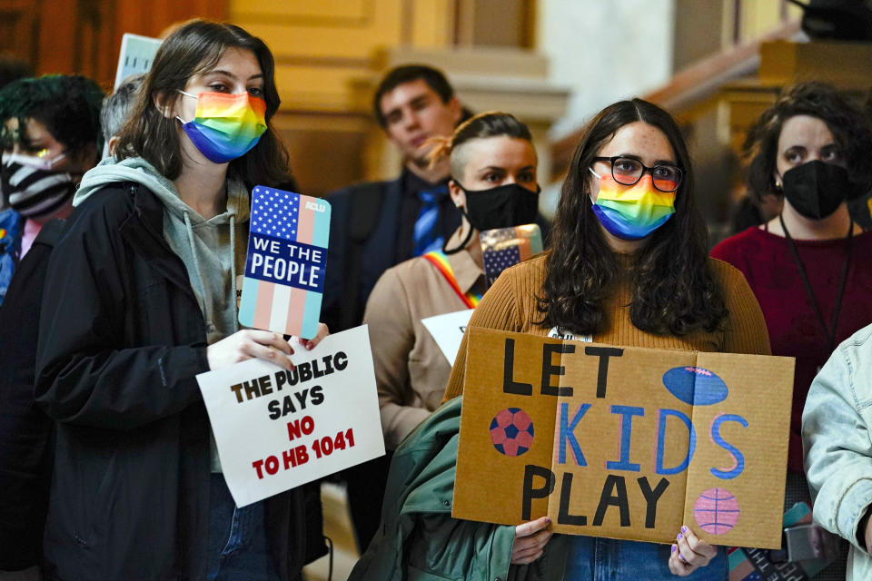 FILE - People gather to protest against HB1041, a bill to ban transgender women and girls from participating in school sports that match their gender identity, during a rally at the Statehouse in Indianapolis, Wednesday, Feb. 9, 2022. The Republican-dominated Indiana Legislature is poised on Tuesday. May 24, 2022, to override the GOP governor's veto of a bill banning transgender females from competing in girls school sports, a step that would have Indiana join more than a dozen other states adopting similar laws in the past two years. (AP Photo/Michael Conroy File)