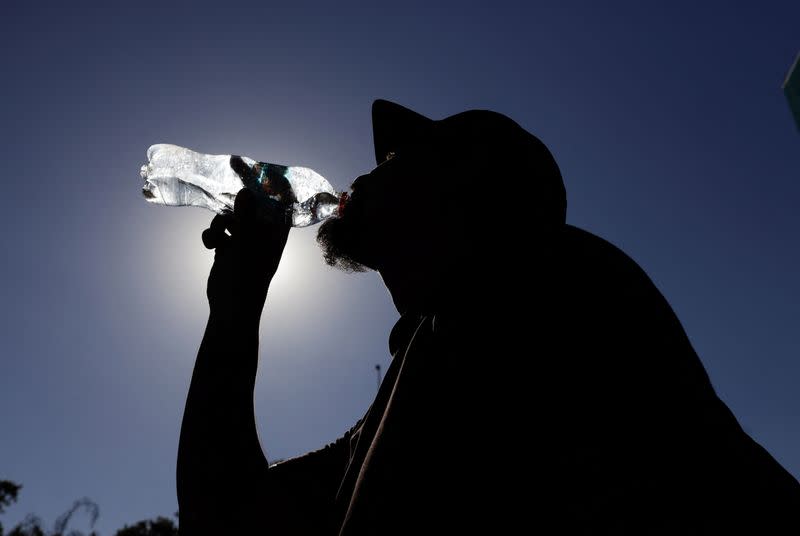 FOTO DE ARCHIVO: Un hombre bebe agua durante una ola de calor, en Santiago