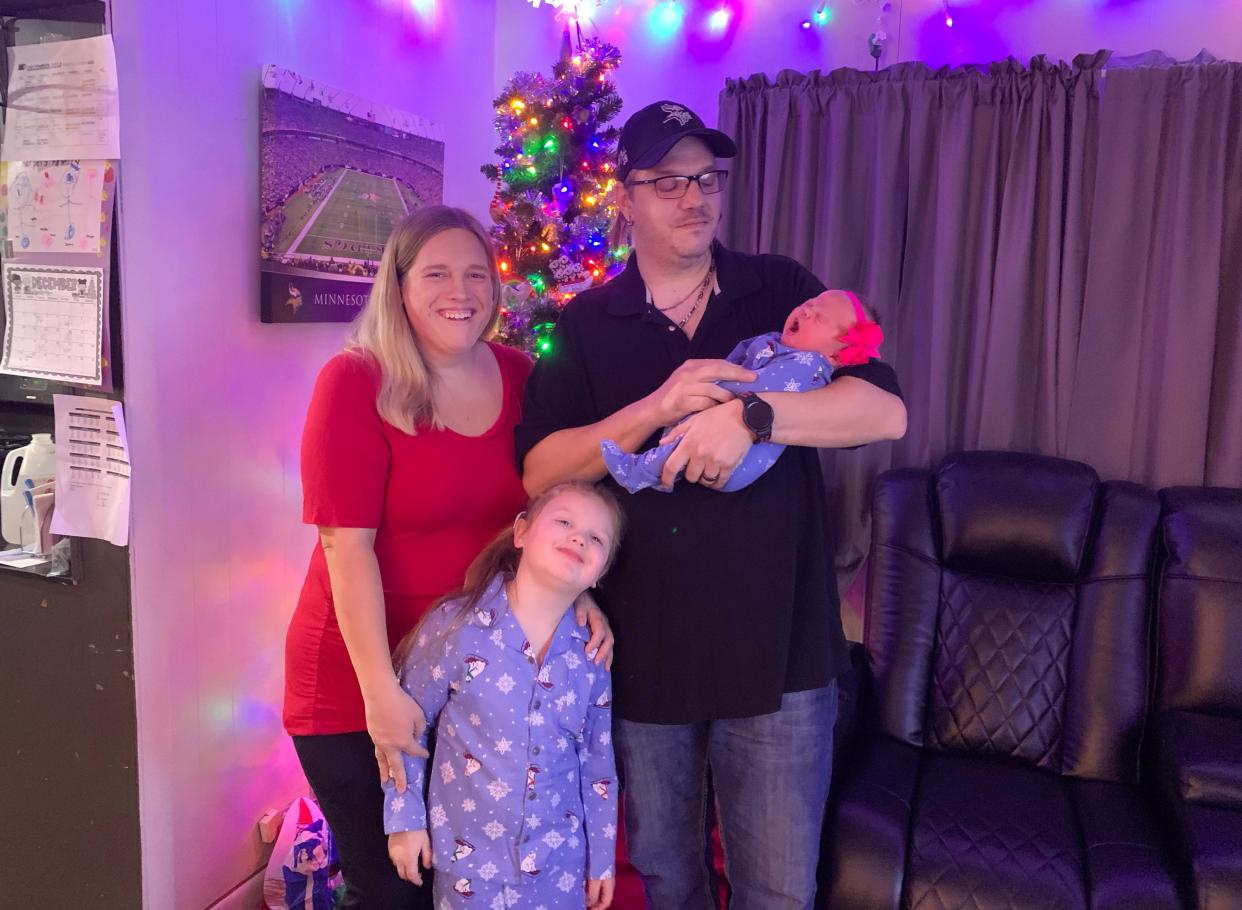 Tony Alten watches Hadley yawn as they pose with Harper and Samantha Alten by the Christmas tree in their home. The family was finally brought together the day before after Hadley spent a month-long stay in the NICU after her surprise birth.