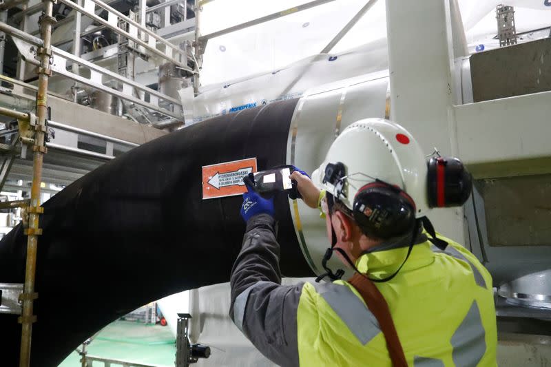 FILE PHOTO: A man takes a picture of the oil pipe on the Equinor's Johan Sverdrup oilfield platform in the North Sea