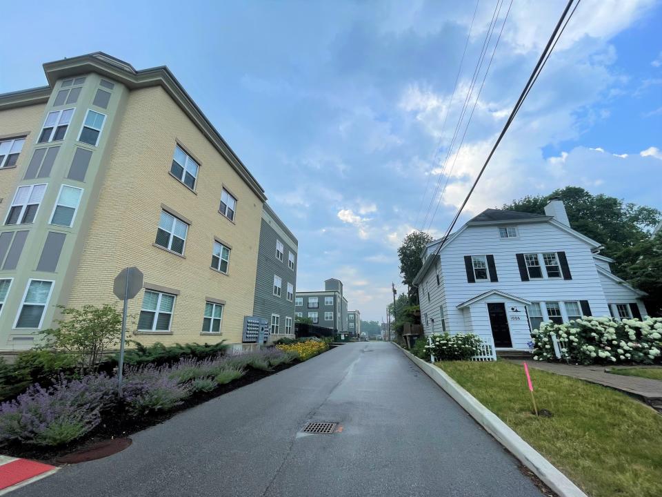 Knute Rockne's first home in South Bend, right, sits across an alley from a luxury student housing complex called The Foundry at Eddy Street Commons. Developers are proposing the home be moved a half-mile west.