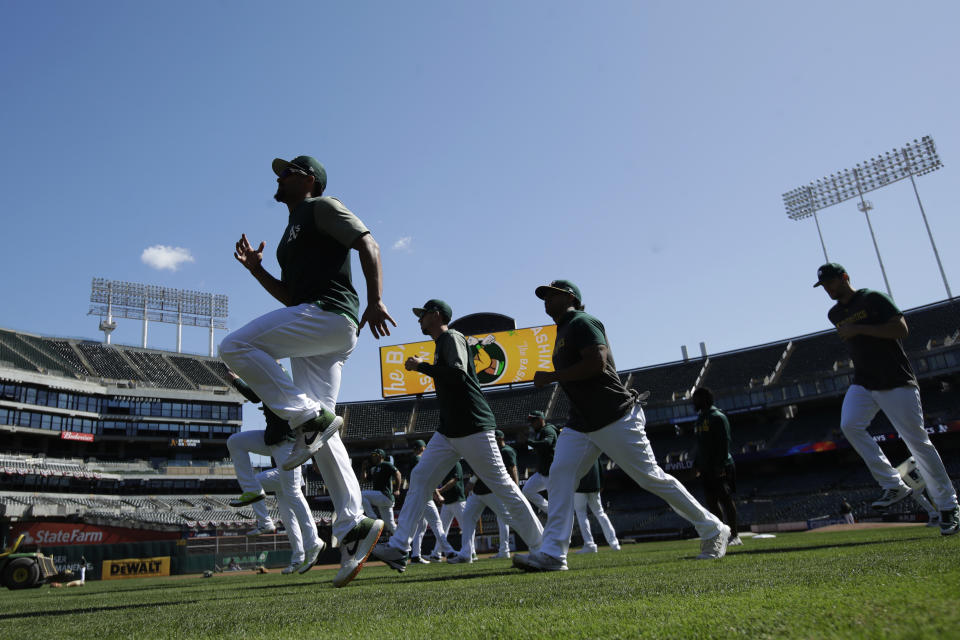 Oakland Athletics players warm up during baseball practice in Oakland, Calif., Tuesday, Oct. 1, 2019. The Athletics are scheduled to face the Tampa Bay Rays in an American League wild-card game Wednesday, Oct. 2. (AP Photo/Jeff Chiu)