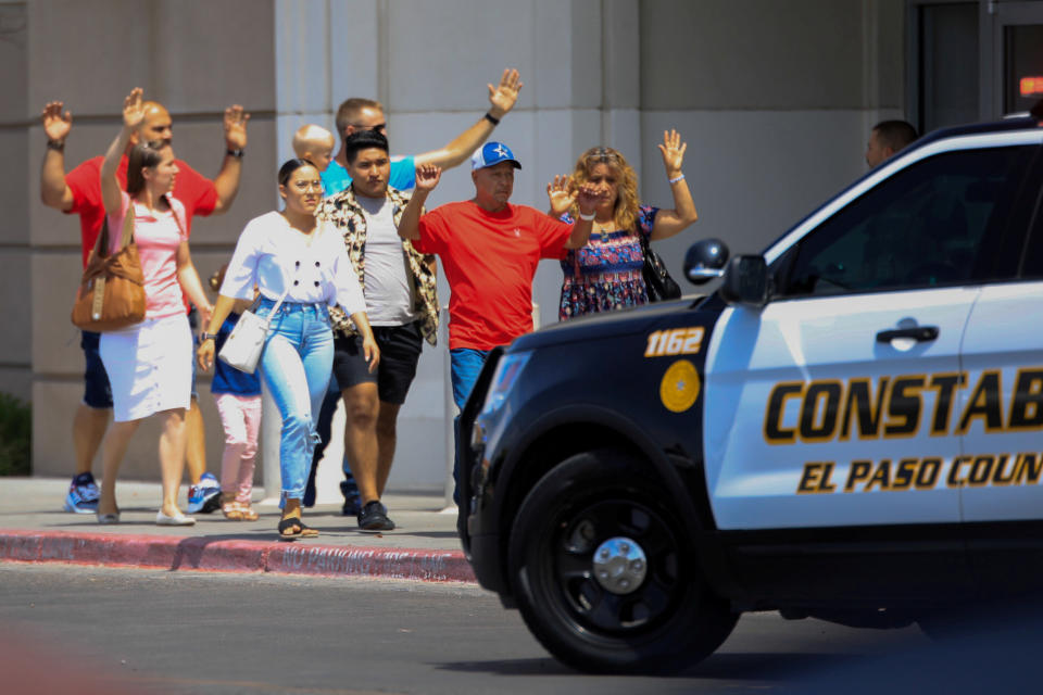 Shoppers exit with their hands up after a mass shooting at a Walmart in El Paso, Texas, on Aug. 3. The store chain has since changed its policy on carrying guns in its stores. (Photo: Jorge Salgado / Reuters)