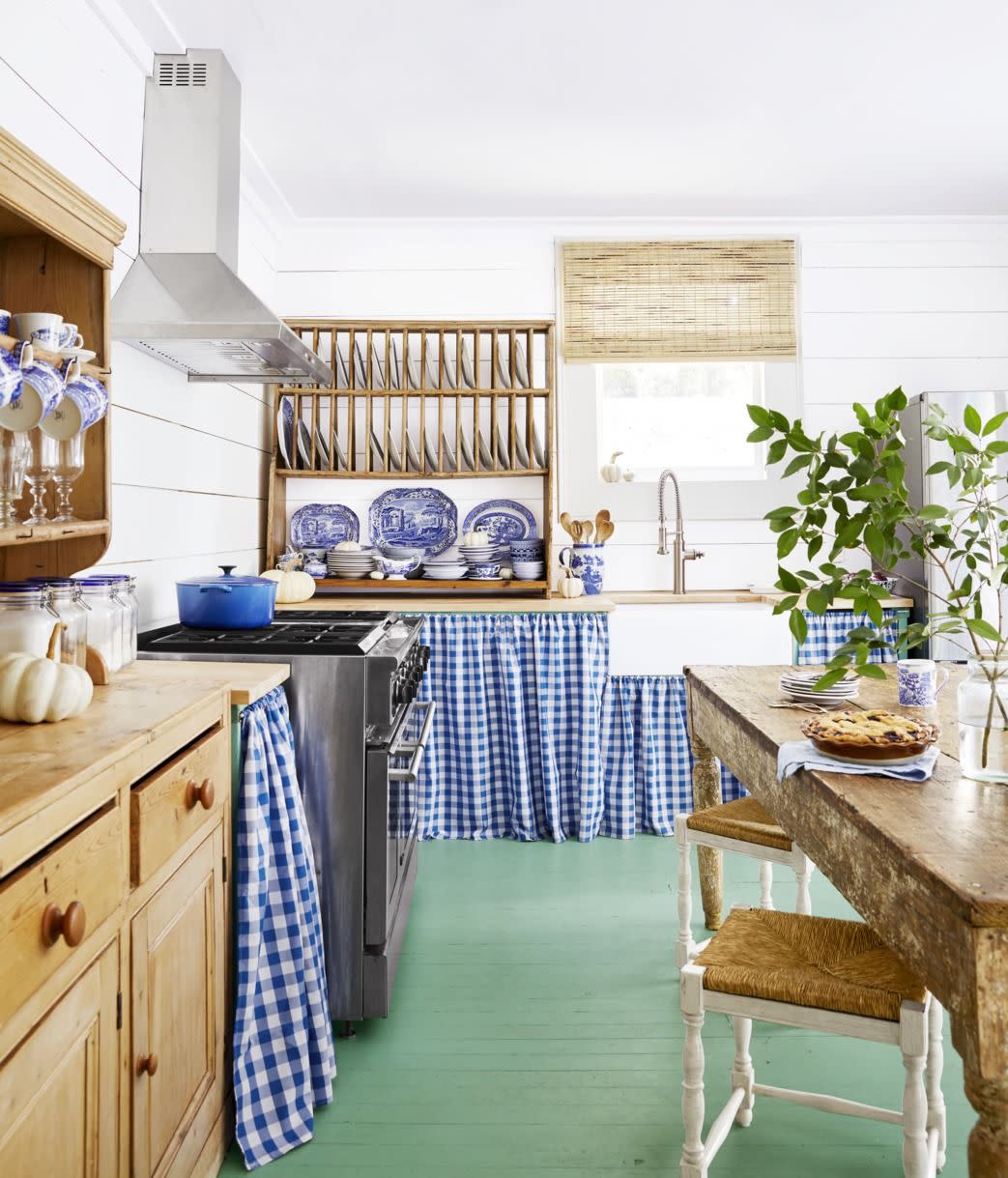 kitchen with green painted floor and gingham skirts around the cabinetry