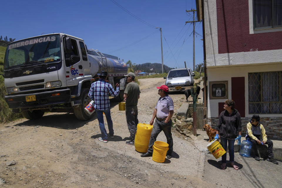 Residents collect water from a truck amid water rationing in La Calera, on the outskirts of Bogota, Colombia, Tuesday, April 16, 2024. Amid a drought linked to the El Niño weather pattern, several regions of Colombia have adopted measures to curb water consumption while reservoirs are low. (AP Photo/Fernando Vergara)