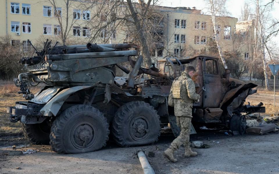 A Ukrainian soldier walks past a destroyed Russian artillery system 'Grad' in Kharkiv - AP Photo/Efrem Lukatsky