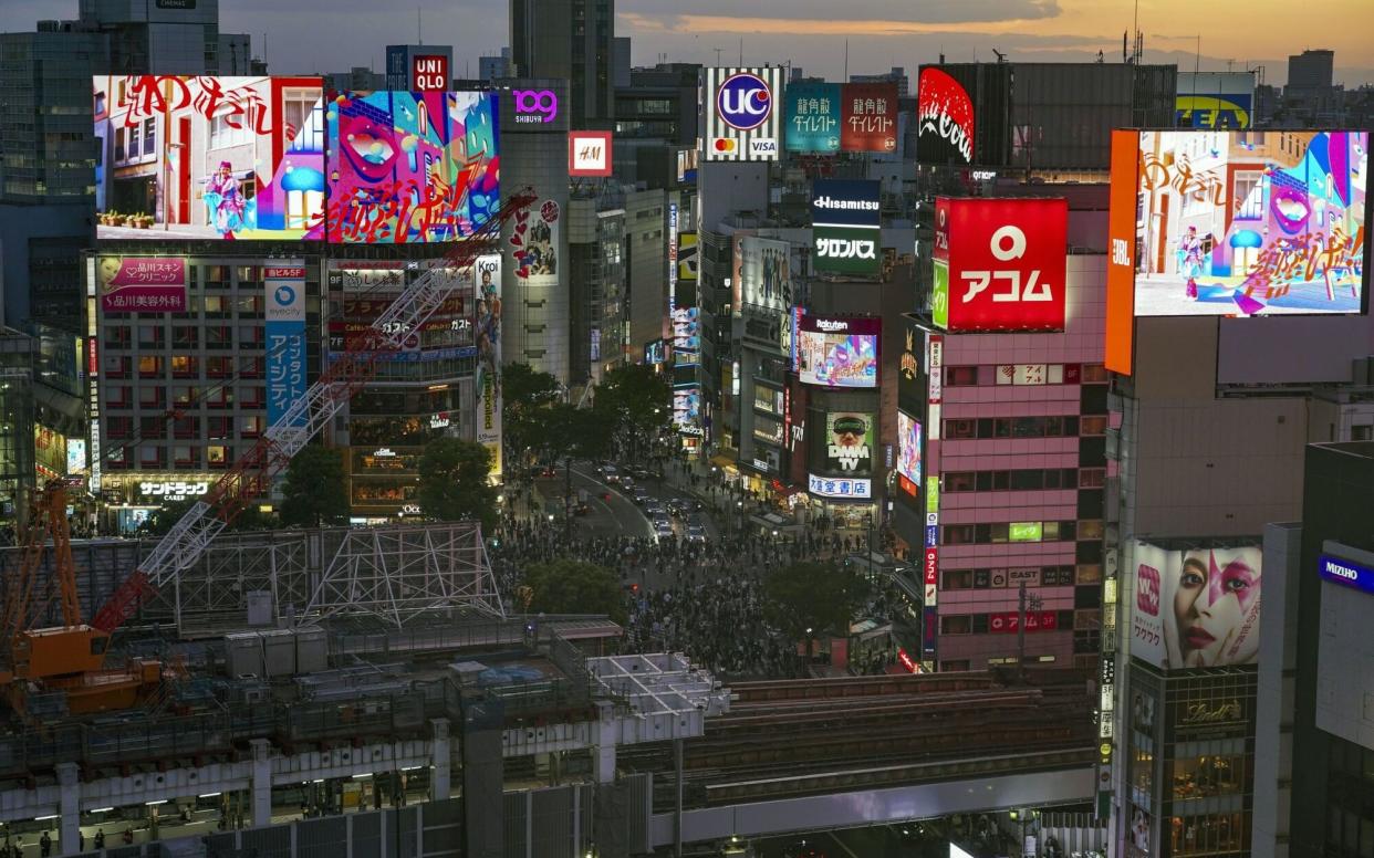 Pedestrians cross an intersection in the Shibuya district of Tokyo, Japan, on Thursday, May 2, 2024