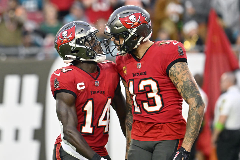 Tampa Bay Buccaneers wide receiver Mike Evans (13) celebrates his 22-yard touchdown reception against the Jacksonville Jaguars with teammate wide receiver Chris Godwin (14) during the first half of an NFL football game Sunday, Dec. 24, 2023, in Tampa, Fla. (AP Photo/Jason Behnken)