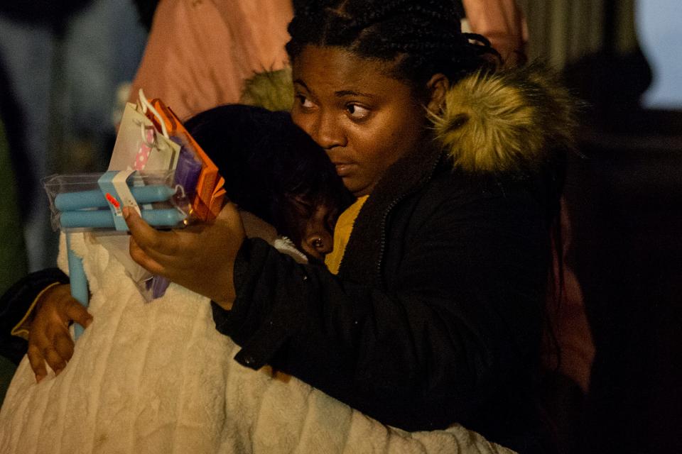 Family members comfort each other at a  vigil Thursday, Jan. 6, 2022 in honor the 12 victims of a rowhouse fire in Philadelphia. The quick-moving fire killed 8 children and four adults in the same family. Another family living in the building escaped.