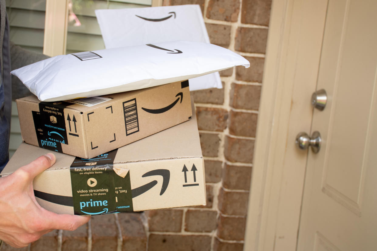 Amazon prime boxes and envelopes delivered to a front door of residential building.