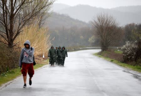 Migrants walk on a road towards a makeshift camp at the Greek-Macedonian border, near the village of Idomeni, Greece March 9, 2016. REUTERS/Stoyan Nenov