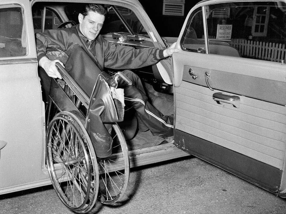 Student with polio lifts his wheelchair into his car