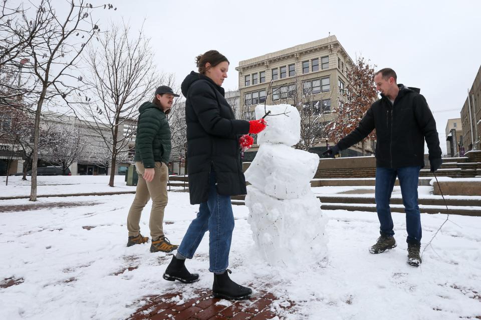 From left to right, Addison Jones, Renae Matthews and Brandon White build a snowman at Park Central Square on Wednesday, Jan. 25, 2023.