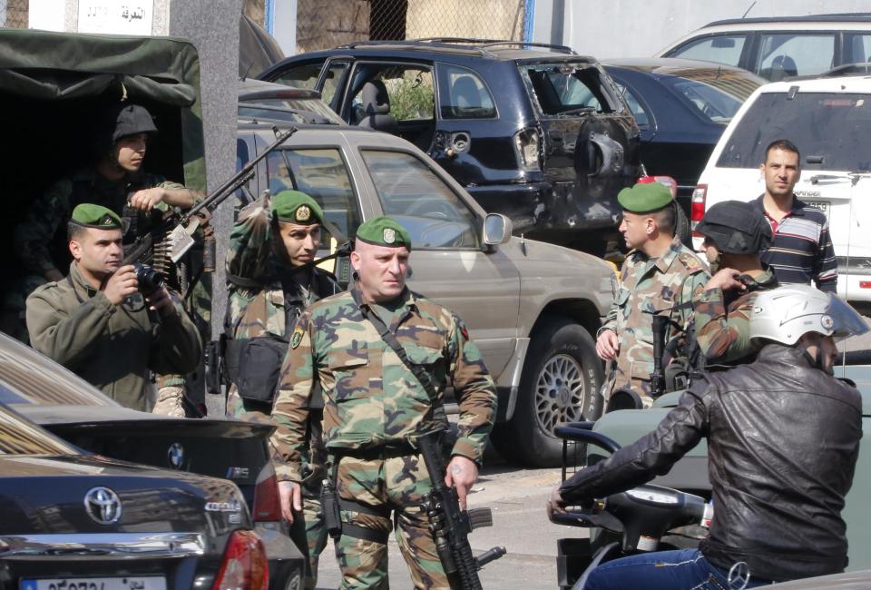 Lebanese army soldiers stand near a booby-trapped car loaded with explosives in the Corniche al-Mazraa district of central Beirut February 12, 2014. Lebanon's army on Wednesday arrested Naim Abbas, a senior al Qaeda-linked militant described by security sources as a "mastermind of car bombs" that targeted Shi'ite areas of the country. Hours after Abbas's arrest, security forces found two booby-trapped cars - one loaded with 100 kg of explosives in the Corniche al-Mazraa district of central Beirut and another in the village of Arsal, near the border with Syria. REUTERS/Mohamed Azakir (LEBANON - Tags: POLITICS CIVIL UNREST MILITARY)