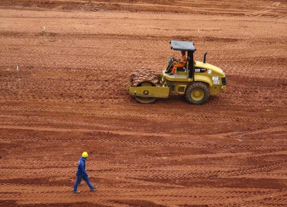 A workman rolls out dirt for the pitch inside the Arena da Baixada stadium as work continues in preparation for the 2014 FIFA World Cup soccer championship in Curitiba December 11, 2013. The 2014 World Cup finals will be held in Brazil from June 12 through July 13. REUTERS/Gary Hershorn (BRAZIL - Tags: SPORT SOCCER WORLD CUP)