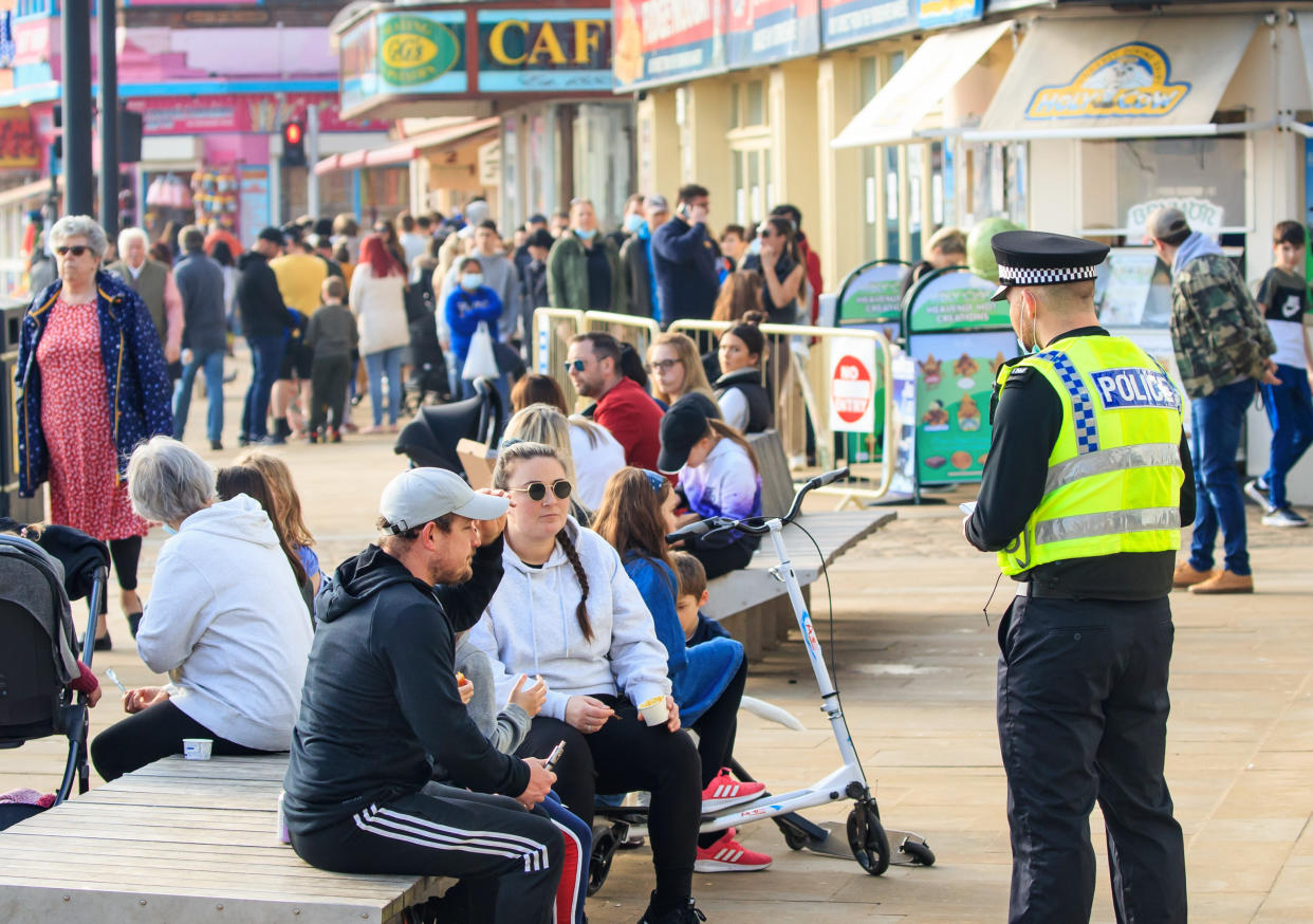 A police officer speaks to people in Scarborough, North Yorkshire, during England's third national lockdown to curb the spread of coronavirus. Picture date: Sunday February 28, 2021.