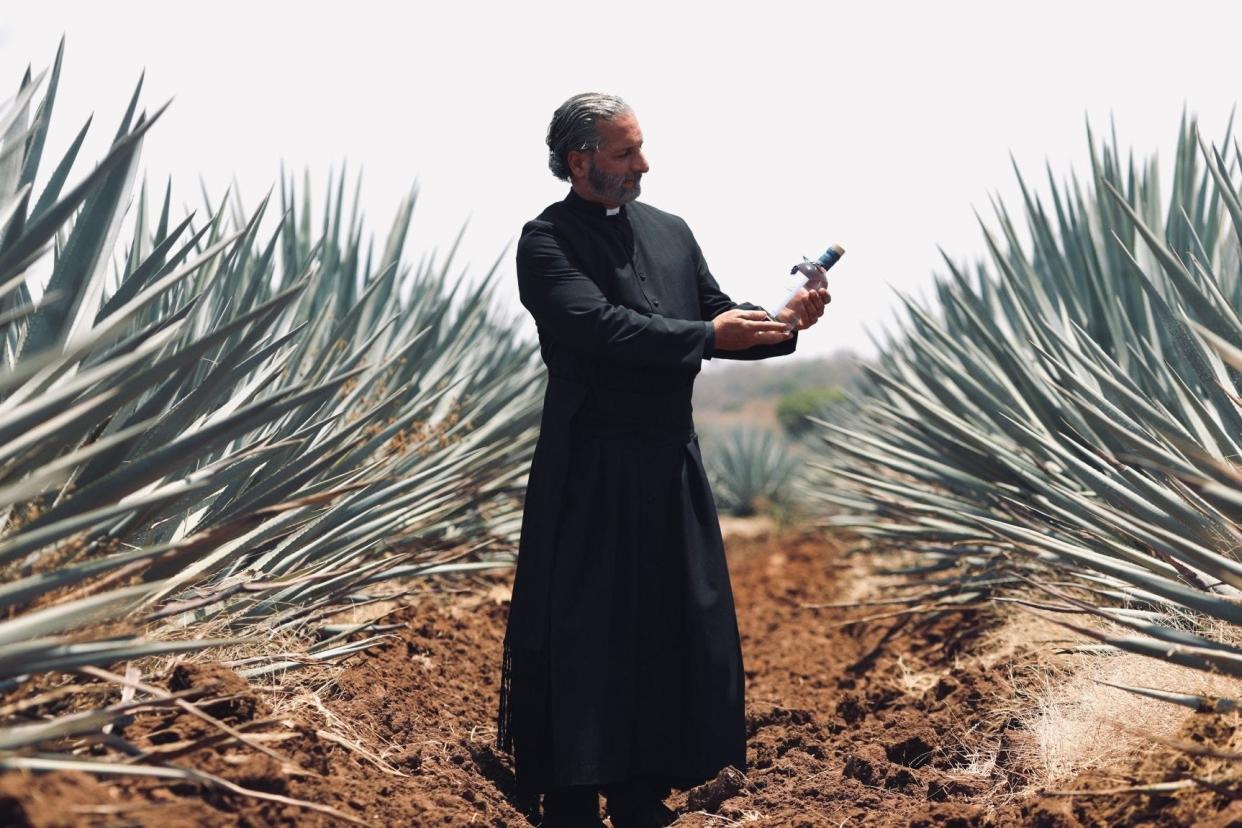 Episcopal priest Rev. Lorenzo Lebrija poses in Jalisco, Mexico with a bottle of Sanctus Aquam tequila.
