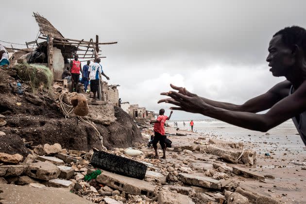 A man repairs his makeshift barrier to protect his house before the next high tide arrives in Bargny, Senegal, on Sept. 3, 2020. (Photo: JOHN WESSELS via Getty Images)