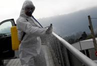 A member of the Military Emergency Unit (UME) sprays disinfectant to prevent the spread of the coronavirus disease (COVID-19) at Cabuenes Hospital during a 15-day state of emergency in Gijon