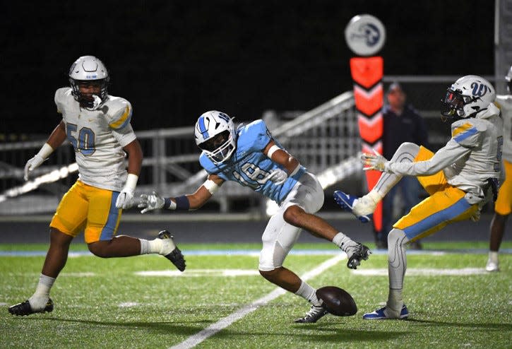 Bartlesville High School's Zach Keen, center, makes a key play during the 31-28 win on Oct. 6, 2023, against visiting Putnam City West High School, at Custer Stadium.