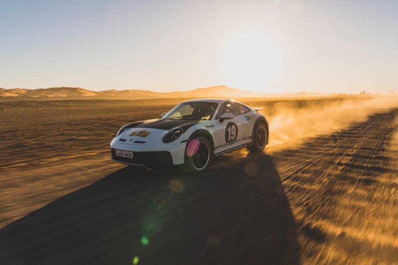 A Porsche 911 Dakar speeds across the desert with a Rallye 1971 livery