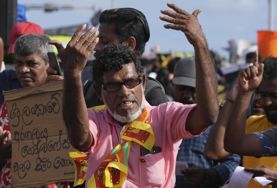 A man shouts slogans demanding the government step down during an ongoing protest outside president's office in Colombo, Sri Lanka, Monday, April 18, 2022. Thousands of Sri Lankans have protested outside President Gotabaya Rajapaksa’s office in recent weeks, demanding that he and his brother, Mahinda, who is prime minister, quit for leading the island into its worst economic crisis since independence from Britain in 1948. (AP Photo/Eranga Jayawardena)