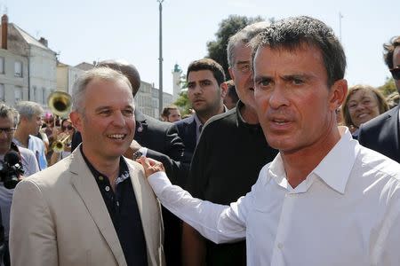 French Prime Minister Manuel Valls and Francois De Rugy, former co-president of the ecologist group at the National Assembly walk trough the city of La Rochelle during the Socialist Party's "Universite d'ete" summer meeting in La Rochelle, France, August 29, 2015. REUTERS/Stephane Mahe