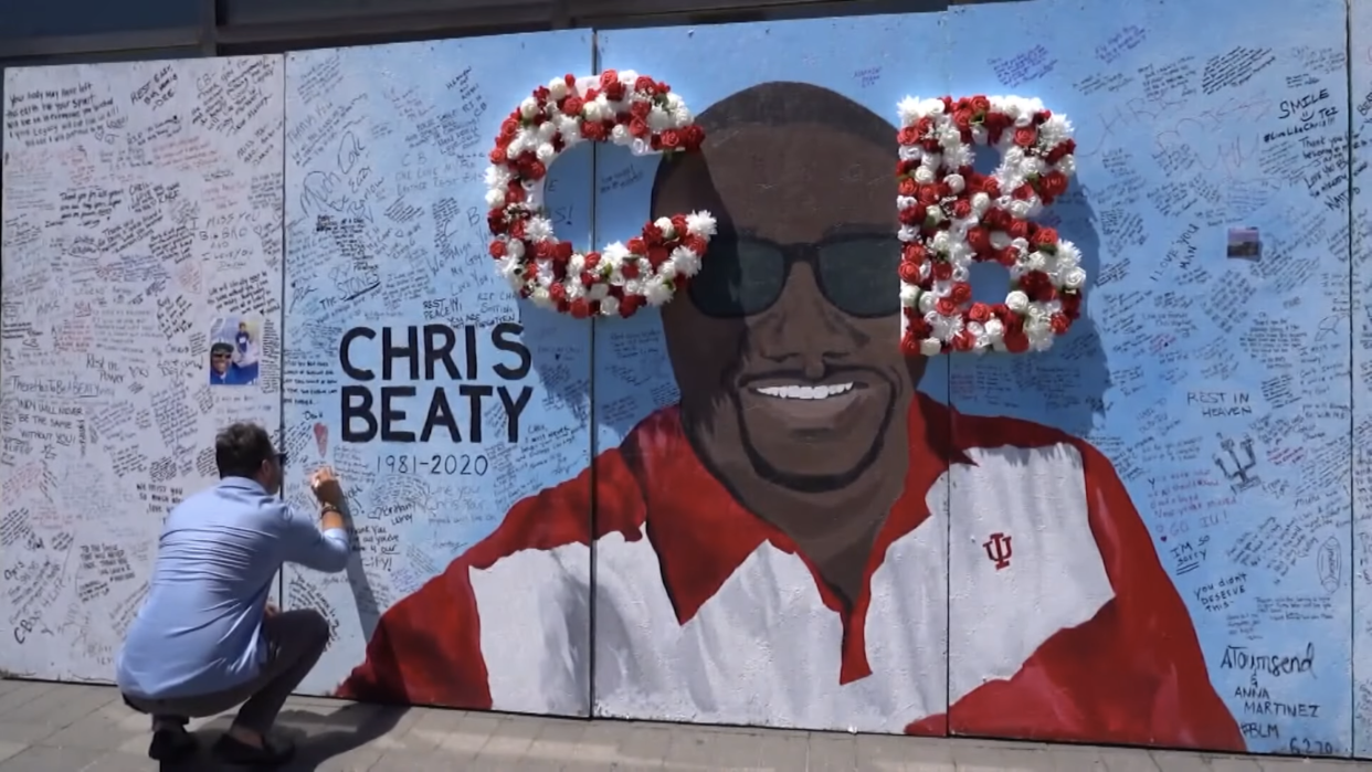 A mural of late Indiana University football player Chris Beaty is signed by a mourner. (Screenshot: YouTube – WTHR)