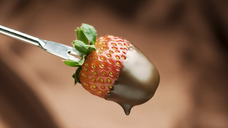 A chocolate covered strawberry on a fork