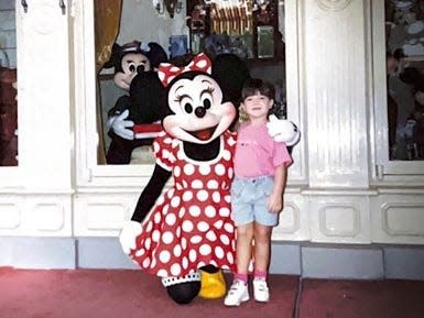 megan posing with minnie mouse as a child on main street usa in disney world 30 years ago