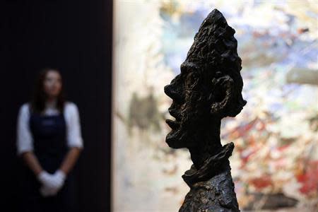 A Sotheby's employee stands behind Alberto Giacometti's artwork "Grande tete de Diego" at Sotheby's auction house in London October 11, 2013. The artwork, with an estimated value of $35-50 million, forms part of the exhibition "Frieze Week" and will be auctioned in New York on November 6. REUTERS/Stefan Wermuth