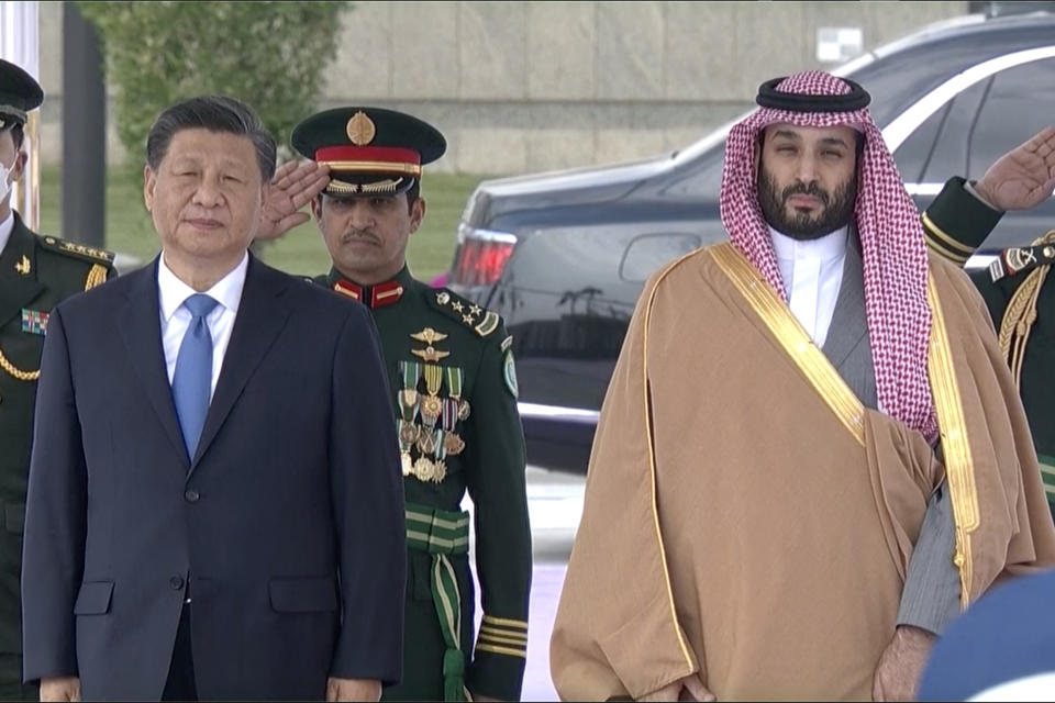 In this image taken from footage by Saudi State TV, Chinese President Xi Jinping, left, listens to the Chinese national anthem next to Saudi Crown Prince and Prime Minister Mohammed bin Salman in Riyadh, Saudi Arabia, Thursday, Dec. 8, 2022. (Saudi Press Agency via AP)