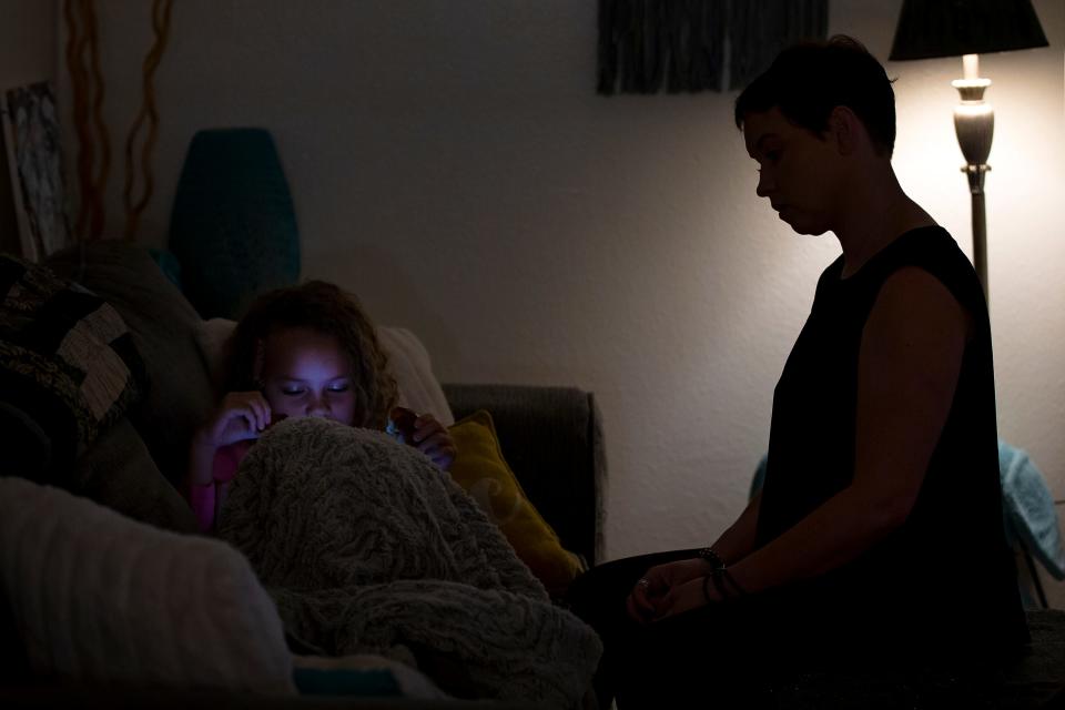 Erin Smith and her 7-year-old daughter sit in the living room of their Gilbert apartment on Feb. 11, 2022.