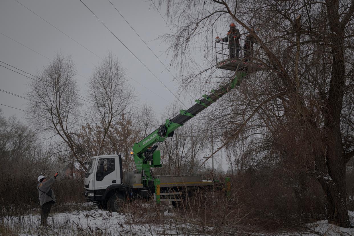 Workers of the electricity supply company DTEK maintain power lines by cutting off excess branches in Kyiv (Copyright 2022 The Associated Press. All rights reserved.)