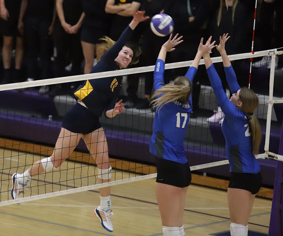 Notre Dame’s Gabby Deery (11) spikes the ball against Holy Trinity defenders Presley Myers (17) and Anna Bendlage (24) in a Class 1A regional final Wednesday in Burlington. Holy Trinity won the match, 3-1.
