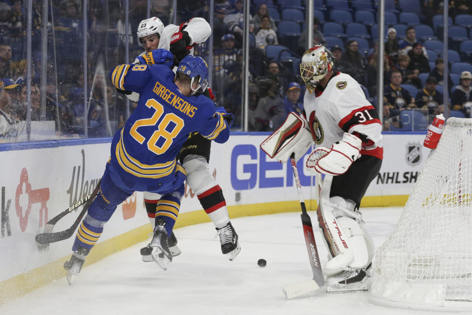 Buffalo Sabres left wing Zemgus Girgensons (28) and Ottawa Senators defenseman Travis Hamonic (23) collide during the first period of an NHL hockey game Thursday, Oct. 13, 2022, in Buffalo, N.Y. (AP Photo/Joshua Bessex)