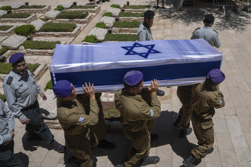 The coffin of Sergeant Almog Shalom, who was killed in battle in the Gaza Strip, is draped in the Israeli flag as it is carried during his funeral at the Mount Herzl military cemetery in Jerusalem, Tuesday, June 11, 2024. (AP Photo/Ohad Zwigenberg)