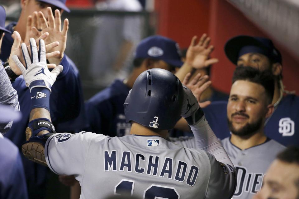 San Diego Padres' Manny Machado, center, celebrates his home run against the Arizona Diamondbacks with teammates, including Luis Torrens, right, during the sixth inning of a baseball game Friday, Sept. 27, 2019, in Phoenix. (AP Photo/Ross D. Franklin)