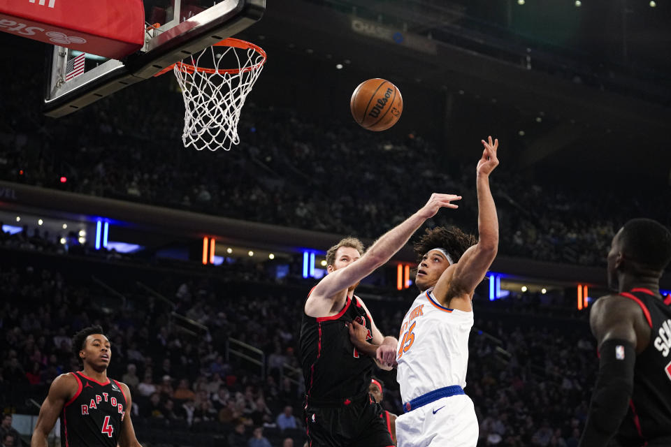 Toronto Raptors center Jakob Poeltl and New York Knicks center Jericho Sims fight for a rebound during the first half of an NBA basketball game in New York, Monday, Dec. 11, 2023. (AP Photo/Peter K. Afriyie)