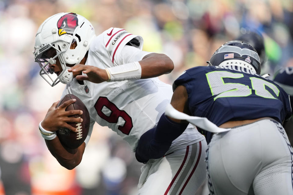 Arizona Cardinals quarterback Joshua Dobbs (9) gets tackled by Seattle Seahawks linebacker Jordyn Brooks during the second half of an NFL football game Sunday, Oct. 22, 2023, in Seattle. (AP Photo/Lindsey Wasson)