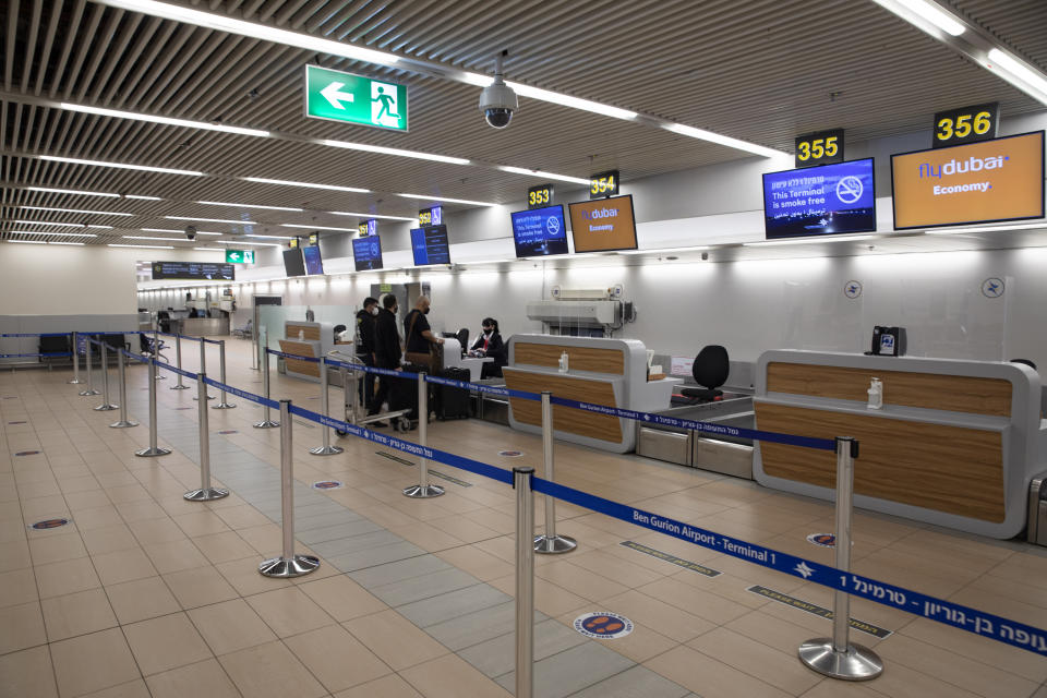 Israelis prepare to fly to Dubai at the Ben Gurion airport near Tel Aviv, Israel, Thursday, Dec. 3, 2020. The Israeli government is urging its citizens to avoid travel to the Gulf states of the United Arab Emirates and Bahrain, citing threats of Iranian attacks. Thursday's travel advisory comes as Iran is threatening to attack Israeli targets following the assassination of its top nuclear scientist last Friday.(AP Photo/Sebastian Scheiner)